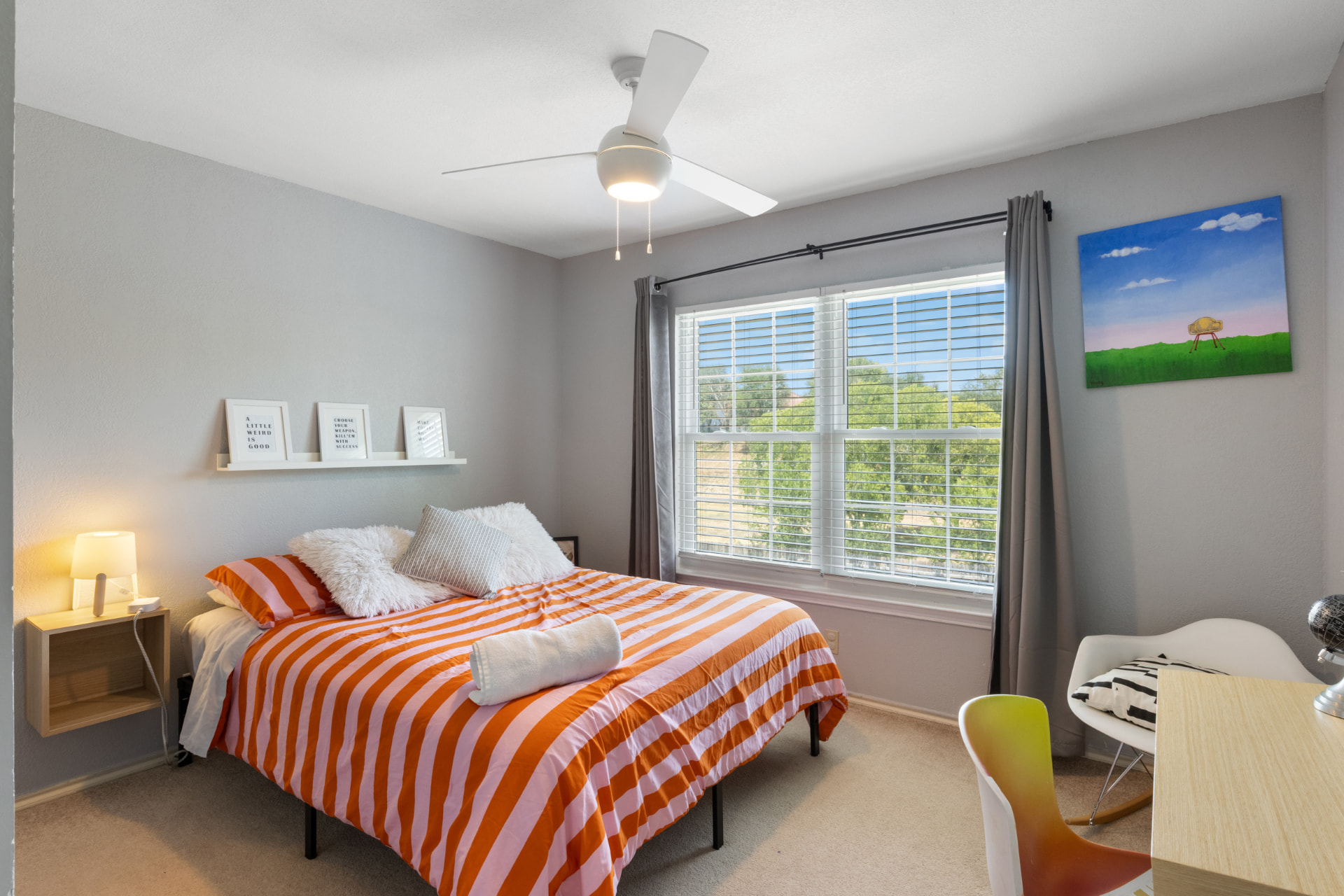 Colorful guest bedroom with striped bedding and teal artwork