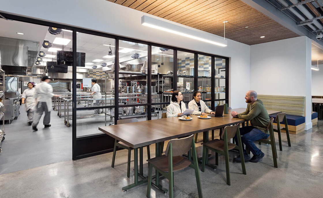 Commercial kitchen and communal dining environment from Nay Reyes's prior-career experience