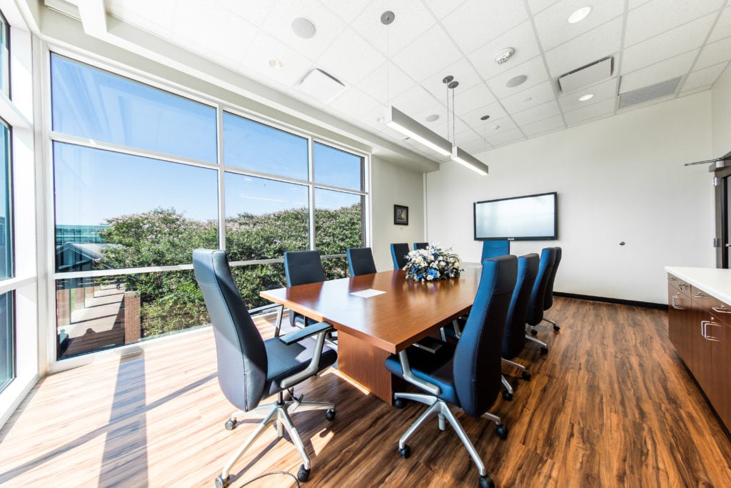 Bright conference room with wood table and blue chairs